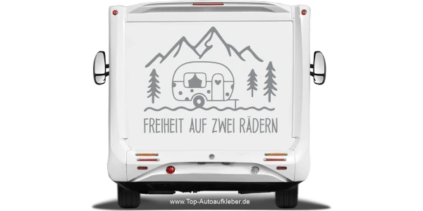 Wohnwagenaufkleber Freiheit auf zwei Rädern auf Heck eines hellen Wohnmobils